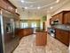 Well-equipped kitchen featuring wooden cabinetry, stainless steel appliances, and tile flooring throughout at 30454 Island Club Dr, Deer Island, FL 32778