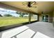 Enclosed patio with view of the green backyard and golf course at 30454 Island Club Dr, Deer Island, FL 32778