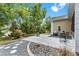 A serene backyard with a stone patio, seating area, and lush landscaping creates a relaxing outdoor space at 6152 Topsail Rd, Lady Lake, FL 32159