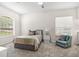Bright bedroom featuring a large window, neutral carpeting, and a cozy sitting area with a comfortable armchair at 6152 Topsail Rd, Lady Lake, FL 32159