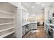 Bright kitchen featuring stainless steel appliances, white cabinets, mosaic backsplash, and a pantry at 6152 Topsail Rd, Lady Lake, FL 32159
