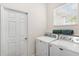 Convenient laundry area with modern appliances and plenty of natural light from the window at 6152 Topsail Rd, Lady Lake, FL 32159