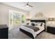 A cozy main bedroom features a bay window, a ceiling fan and neutral decor at 6152 Topsail Rd, Lady Lake, FL 32159