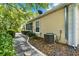 A charming stone path leads along the side of the house, complemented by lovely garden beds and greenery at 6152 Topsail Rd, Lady Lake, FL 32159