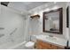 Well-lit bathroom featuring a shower/tub, white tile, and modern vanity with a wood-trimmed mirror at 628 Mount Homer Rd # 4B, Eustis, FL 32726