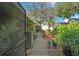 Exterior side yard featuring a wood walkway, lush plants, and an air conditioning unit at 628 Mount Homer Rd # 4B, Eustis, FL 32726