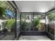 Enclosed patio with tile floor, black framing, bright sunlight, and various potted plants at 628 Mount Homer Rd # 4B, Eustis, FL 32726