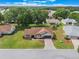 Aerial view of charming home featuring a brick driveway, lush green lawn, and tasteful landscaping at 6410 Tildon Ct, Leesburg, FL 34748
