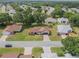 Aerial view of a beautiful home with mature landscaping, manicured lawns, and a brick driveway at 6410 Tildon Ct, Leesburg, FL 34748