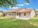 Backyard view of home featuring green lawn and mature landscaping at 6410 Tildon Ct, Leesburg, FL 34748