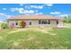 Backyard view of home featuring green lawn and mature landscaping at 6410 Tildon Ct, Leesburg, FL 34748