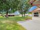 Backyard view of house with concrete patio, green grass, and mature trees at 6410 Tildon Ct, Leesburg, FL 34748