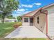 View of a concrete backyard patio with a beige house, brown trim, and green grass at 6410 Tildon Ct, Leesburg, FL 34748
