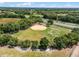 This aerial view showcases the community baseball field, bordered by trees and a highway at 6410 Tildon Ct, Leesburg, FL 34748
