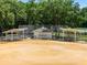 Baseball field with a chain link fence, covered dugouts and manicured infield dirt at 6410 Tildon Ct, Leesburg, FL 34748