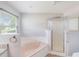 Bright bathroom featuring a soaking tub and a separate glass-enclosed shower at 6410 Tildon Ct, Leesburg, FL 34748