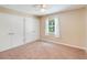 Bright bedroom features neutral carpet, dual closets, and a ceiling fan at 6410 Tildon Ct, Leesburg, FL 34748