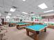 Well-lit billiards room featuring multiple tables, comfortable seating, and classic decor for leisure activities at 6410 Tildon Ct, Leesburg, FL 34748