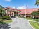 Welcoming exterior featuring a vibrant red roof and meticulously landscaped grounds at 6410 Tildon Ct, Leesburg, FL 34748