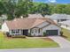 Inviting one-story home with a lush green lawn, colorful landscaping, and a convenient two-car garage at 6410 Tildon Ct, Leesburg, FL 34748