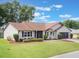 Well-maintained one-story home boasting green lawn, mature landscaping, and attached two-car garage at 6410 Tildon Ct, Leesburg, FL 34748