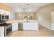 Bright kitchen with stainless steel appliances, white cabinetry, and a breakfast bar overlooking the living area at 6410 Tildon Ct, Leesburg, FL 34748