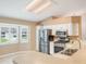 Kitchen with stainless steel appliances, white cabinets, and a large window offering ample natural light at 6410 Tildon Ct, Leesburg, FL 34748
