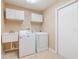 Functional laundry area with washer, dryer, sink, and storage cabinets at 6410 Tildon Ct, Leesburg, FL 34748