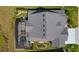 Overhead view of property showing the backyard screened in lanai, lush landscaping, and paver driveway at 6444 Mcknight Loop, The Villages, FL 34762