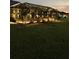 Backyard at night featuring a covered and screened patio with mature landscaping at 6444 Mcknight Loop, The Villages, FL 34762