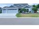 Charming single-story home with blue exterior, manicured lawn, and well-maintained landscaping at 6444 Mcknight Loop, The Villages, FL 34762