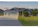 Inviting single-story home boasting a three-car garage, beautifully maintained lawn, and lush landscaping, ideal for a Gathering at 6444 Mcknight Loop, The Villages, FL 34762