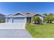Charming single-Gathering home with a three-car garage, manicured lawn, mature landscaping, and a welcoming facade at 6444 Mcknight Loop, The Villages, FL 34762