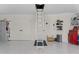 Well-organized garage features an attic ladder, storage cabinets, and epoxy flooring at 6444 Mcknight Loop, The Villages, FL 34762
