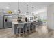 Modern kitchen with stainless steel appliances, large island with pendant lighting, and a separate dining area at 6444 Mcknight Loop, The Villages, FL 34762