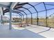 Screened lanai featuring a spa, chairs, and tranquil backyard views at 6444 Mcknight Loop, The Villages, FL 34762
