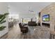Spacious living room with stylish fireplace, modern furnishings, and access to outdoor patio at 6444 Mcknight Loop, The Villages, FL 34762