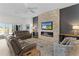 Comfortable living room featuring a stone accent wall with a fireplace and TV, perfect for relaxation at 6444 Mcknight Loop, The Villages, FL 34762