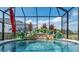 Backyard view of pool featuring a small waterfall and lush landscaping at 6444 Mcknight Loop, The Villages, FL 34762