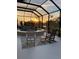 Screened-in pool area with chairs and a beautiful landscape view at sunset at 6444 Mcknight Loop, The Villages, FL 34762