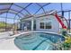 Screened pool area with spa, lush landscaping, and seating at 6444 Mcknight Loop, The Villages, FL 34762
