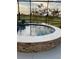 Beautiful outdoor enclosed pool with stacked stone surround and views of the backyard at 6444 Mcknight Loop, The Villages, FL 34762