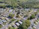 Aerial view of a charming neighborhood, surrounded by lush greenery and mature trees at 701 Cottage Park Ln, Leesburg, FL 34748