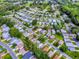 An aerial image shows a serene community, with a spotlighted home located among mature trees near the golf course at 701 Cottage Park Ln, Leesburg, FL 34748