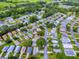 An aerial view highlights a quiet, lush neighborhood with a featured property nestled near a golf course and green spaces at 701 Cottage Park Ln, Leesburg, FL 34748