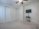 Bedroom features neutral carpet, ceiling fan, and double closets, providing ample storage at 701 Cottage Park Ln, Leesburg, FL 34748