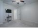 Bright bedroom with neutral carpet, a ceiling fan, and a wall-mounted television set at 701 Cottage Park Ln, Leesburg, FL 34748