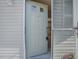 Open doorway reveals a glimpse of a tidy kitchen with white cabinets inside the house at 701 Cottage Park Ln, Leesburg, FL 34748