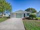 Charming single-story home with a well-maintained lawn and a convenient attached garage at 701 Cottage Park Ln, Leesburg, FL 34748