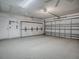 Huge garage with multiple fans, storage, a garage door and exterior door at 701 Cottage Park Ln, Leesburg, FL 34748